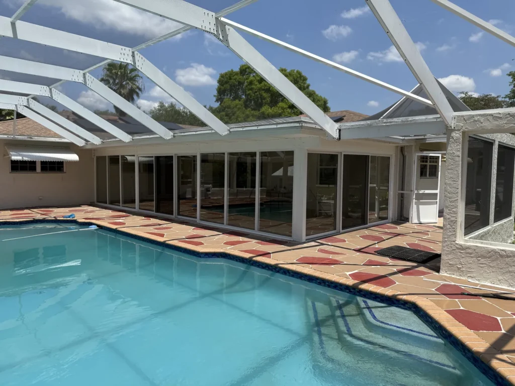 Pool patio in Broward County enclosed with impact glass panels