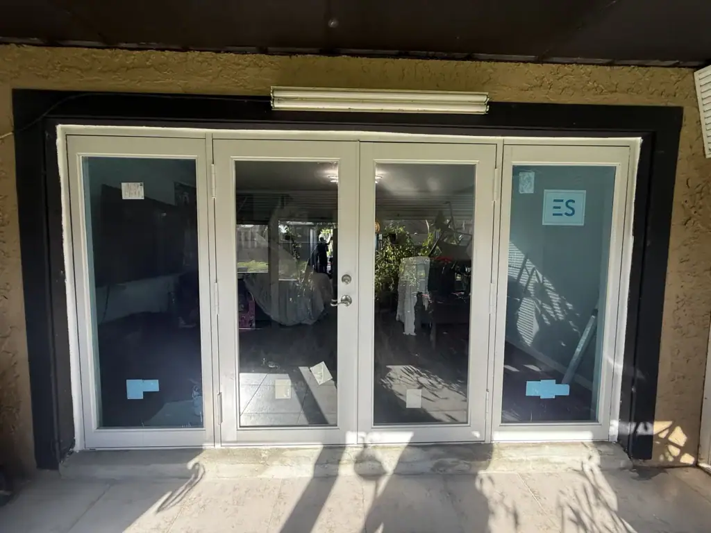 New white impact French doors with sidelites, labels still on the glass