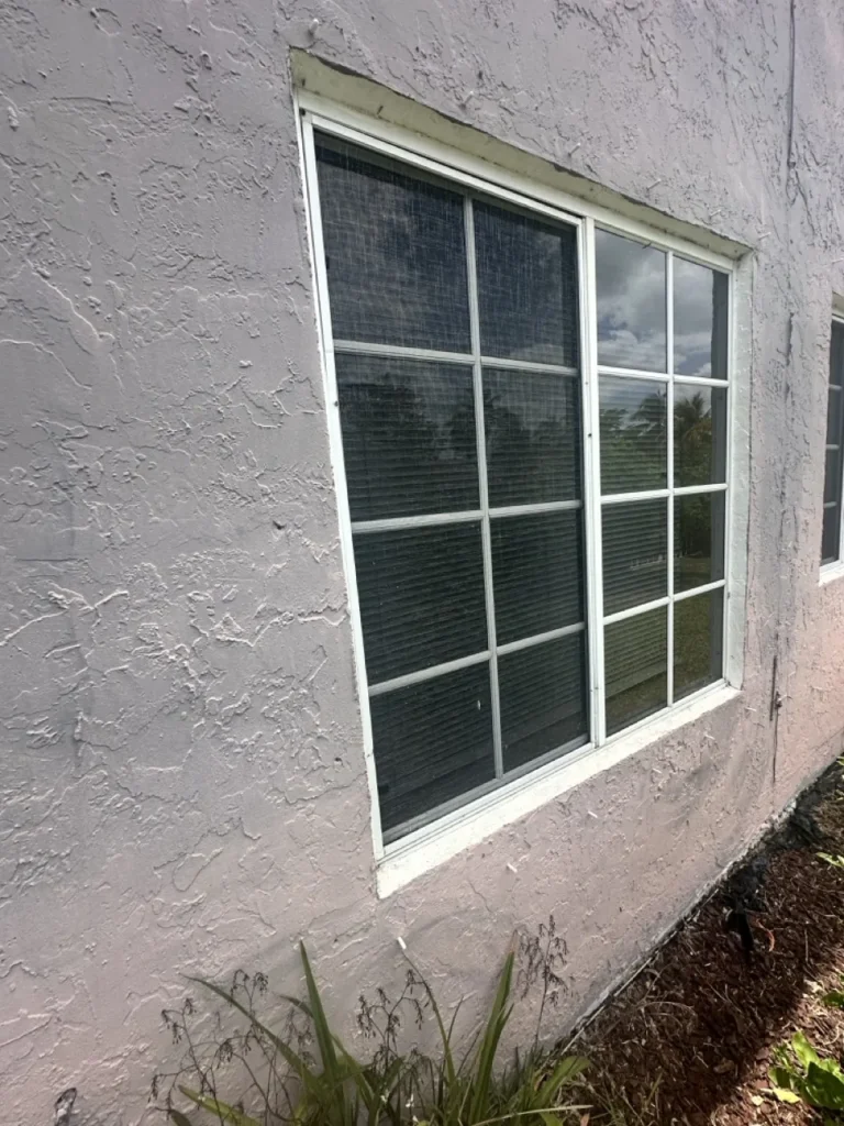 Impact window with colonial grids on a stucco home