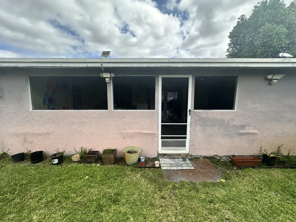 Rear of a single-story ranch home with new impact windows and a new door