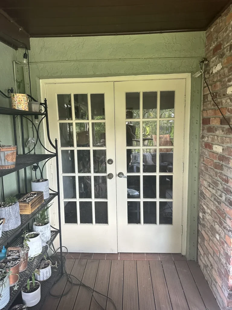 White French doors with grids opening onto a covered wood deck