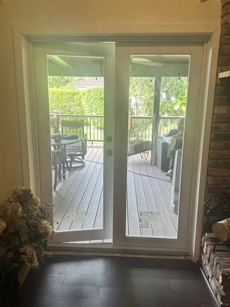 White French doors opening from the living room onto a backyard deck